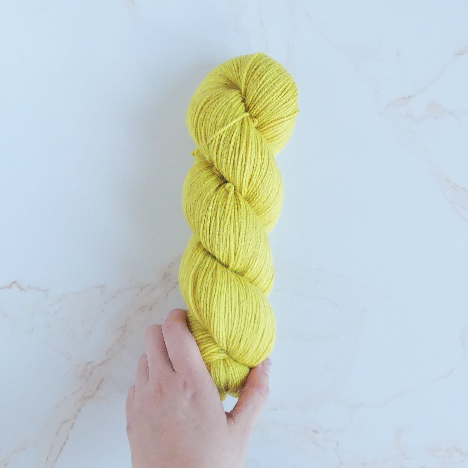 The Wandering Flock Baby Paca Yarn - Limeade Colorway, made from 50% Extra Fine Merino, 30% Baby Alpaca, and 20% Nylon, with a high twist 4-ply structure, ideal for Lite Sport or fat fingering substitute.