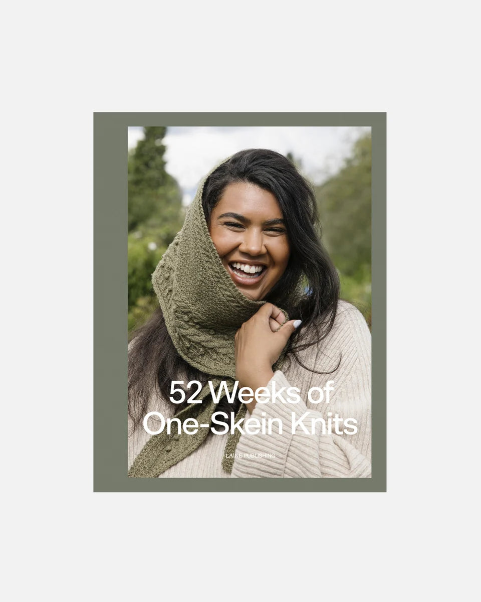 Cover of the book "52 Weeks of One-Skein Knits" featuring a person with a green, cable knit scarf draped over their head against natural outdoor scenery.