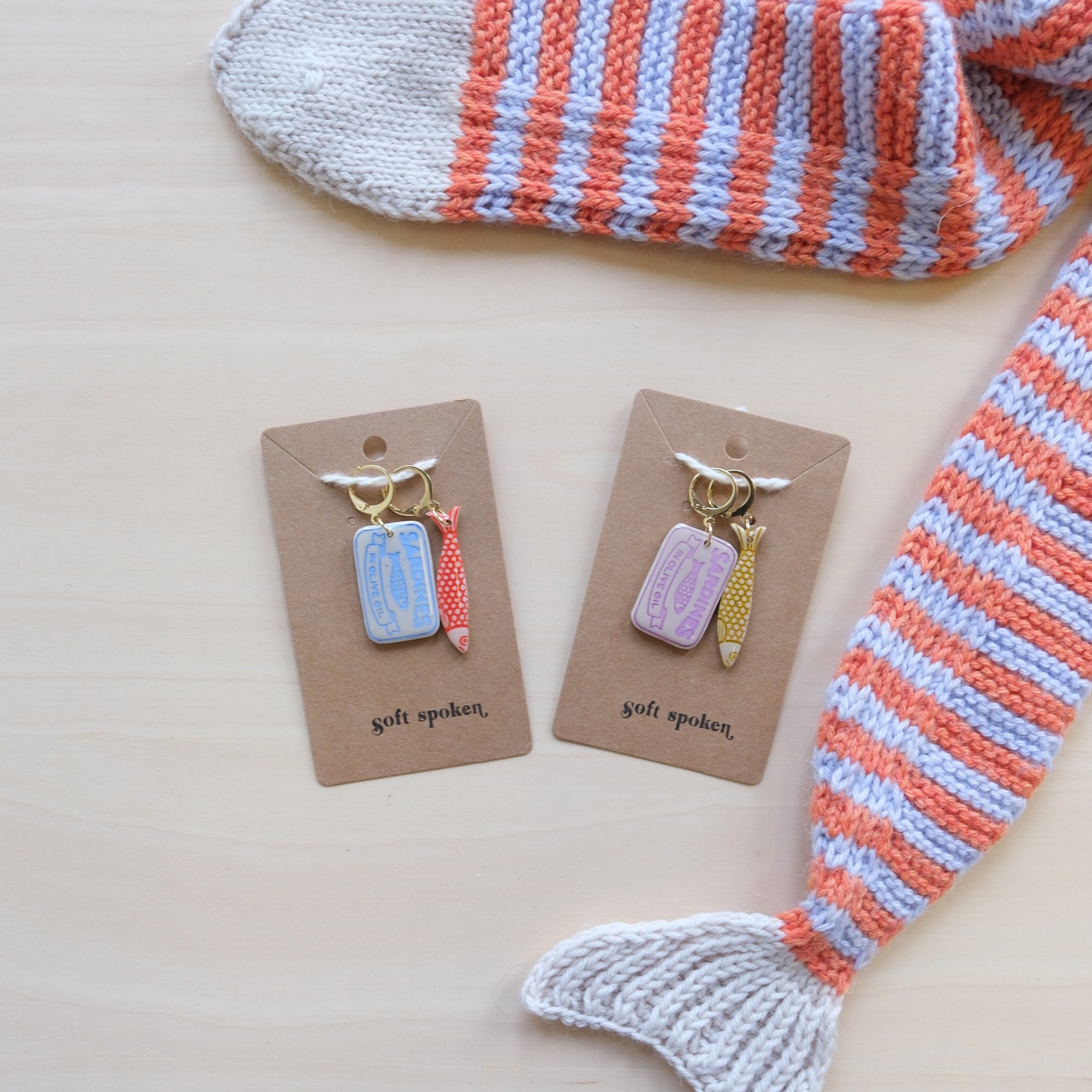 Two sets of progress markers on display cards with a striped fish-shaped scarf in the background