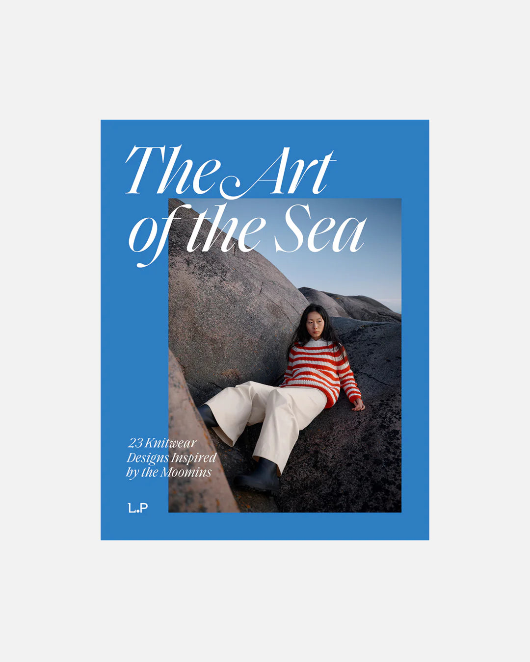 Book cover for "The Art of the Sea" featuring a person wearing a red and white striped knit sweater and sitting on some large boulders, on a white background.